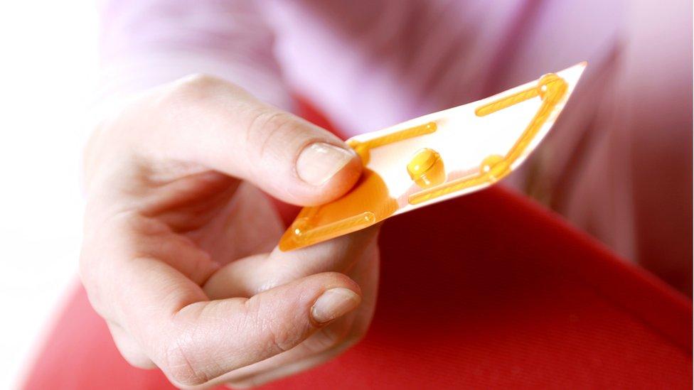 Woman holding an emergency contraceptive pill which contains a synthetic hormone called levonorgestrel that disrupts ovulation.