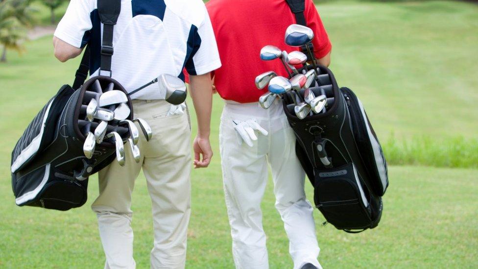 Two golfers walking.