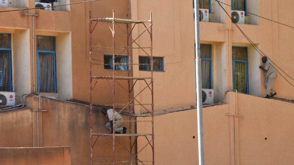 Men are seen escaping from the military HQ after it came under attack in Ouagadougou