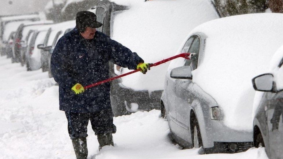 Man clearing snow from car in Glasgow