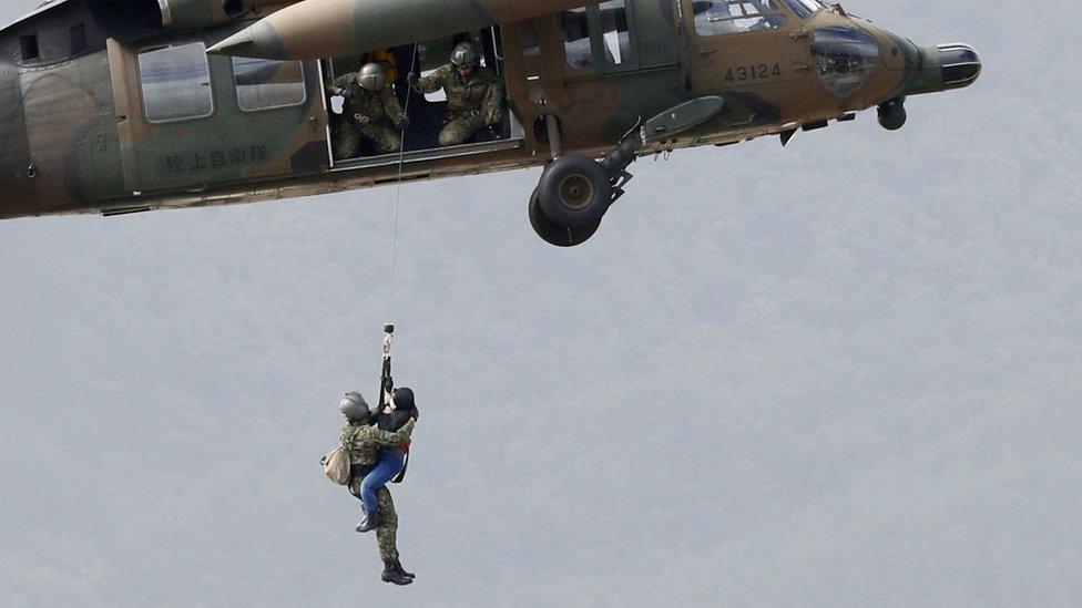 A rescue helicopter saves a Japanese woman from floods in Nagano