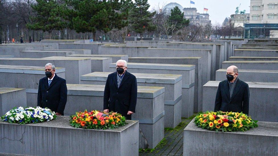 German President Frank-Walter Steinmeier the Speaker of Israel's Knesset parliament Mickey Levy and German Chancellor Olaf Scholz arrange wreaths at Berlin's Holocaust memorial on 27 January 2022