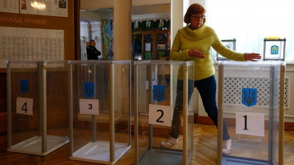 A woman sets up a voting station in Kiev