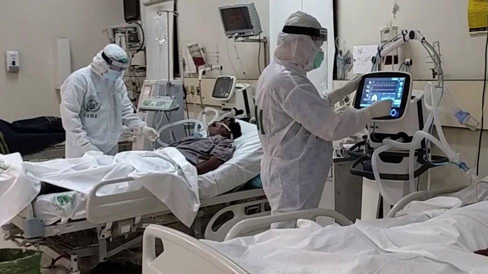 Two doctors work on patients in intensive care