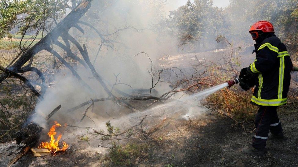 A firefighter extinguishes a fire that broke out in Cogolin in the Var region of southern France