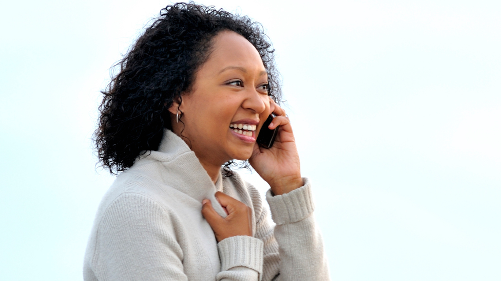 A woman talking on a phone on Port Elizabeth's pier, South Africa