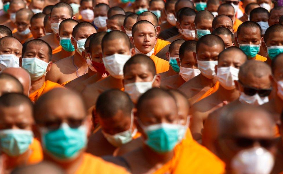 Buddhist monks of the Dhammakaya sect temple pray as they confront with Thai policemen outside the temple in Pathum Thani, north of Bangkok, Thailand, Monday, 20 February 2017.