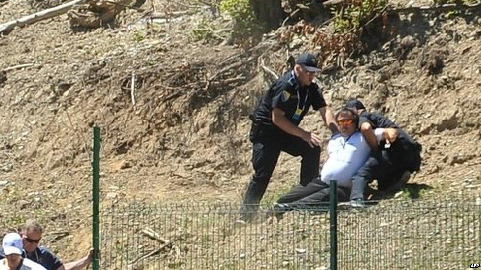 Bosnian police officers arrest a protester suspected of having taken part in the attack on Mr Vucic