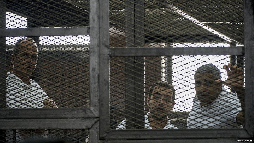 al-Jazeera news channel's Australian journalist Peter Greste (L) and his colleagues, Egyptian-Canadian Mohamed Fadel Fahmy (R) and Egyptian Baher Mohamed (C), listen to the verdict inside the defendants cage during their trial 23 June 2015