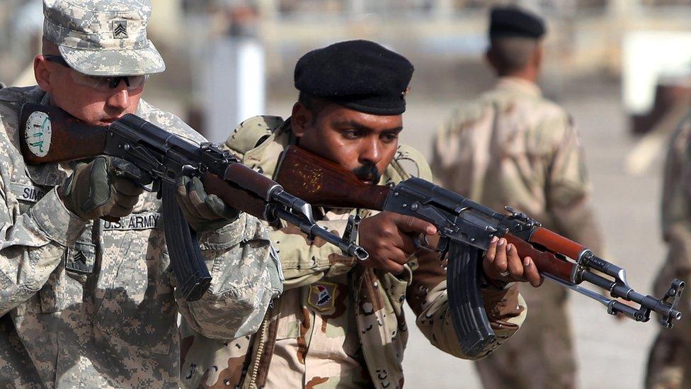 Two soldiers have weapons at their shoulders