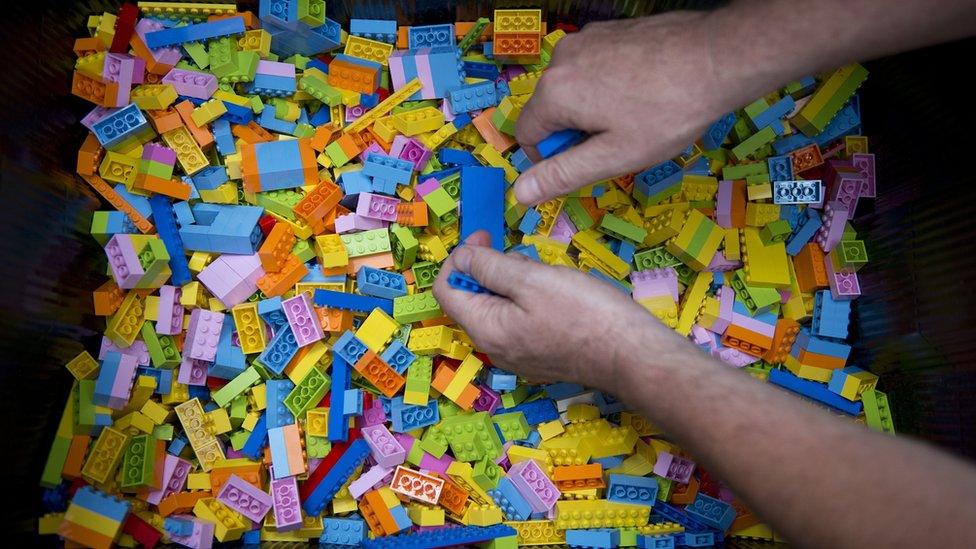 Hands playing with Lego