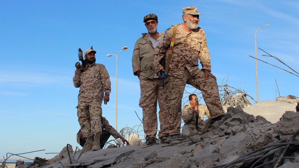 Fighters of Libyan forces allied with the U.N.-backed government stand atop the ruins of a house as they are close to securing last Islamic State holdouts in Sirte