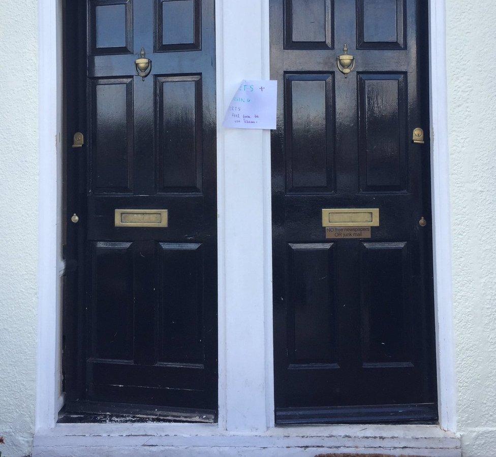 Double doors with a sign offering toilets, tea and charging ports