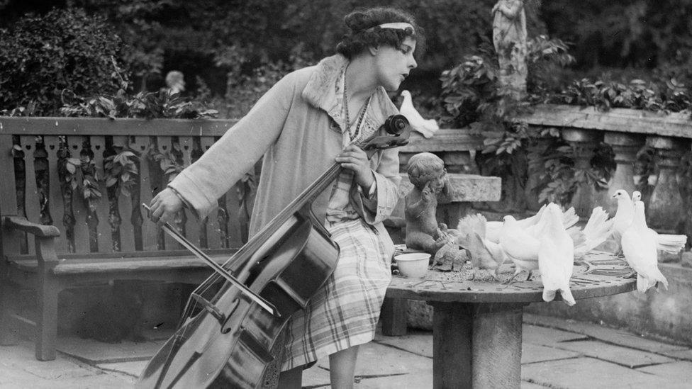 Beatrice playing cello in her garden