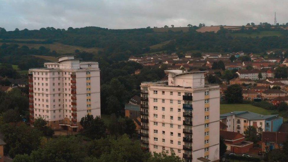 An aerial view of flat buildings in Hartcliffe. The film is washed with a dark filter