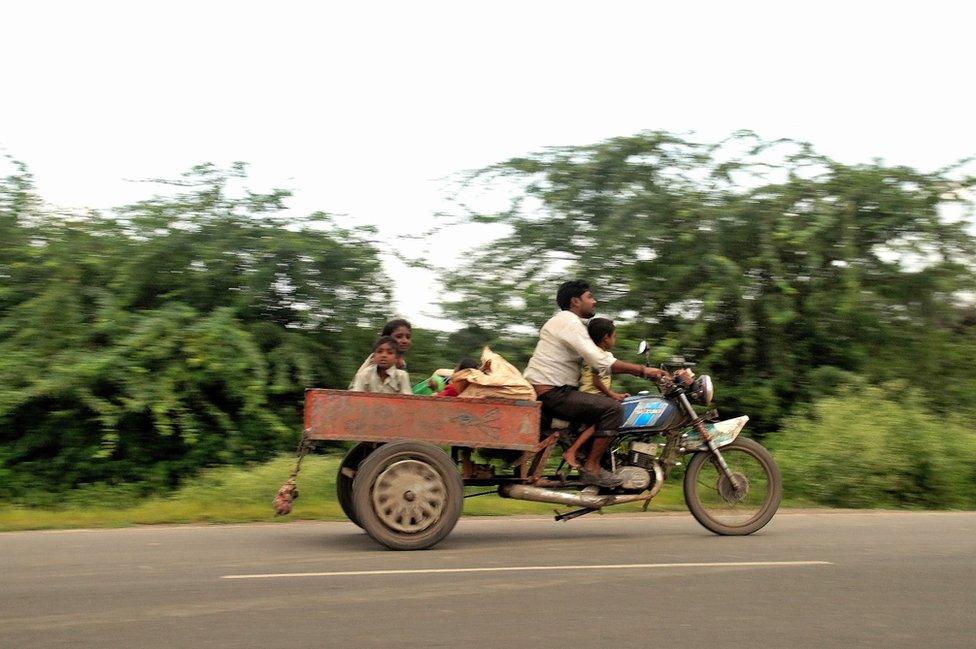 A man on a scooter with his family.