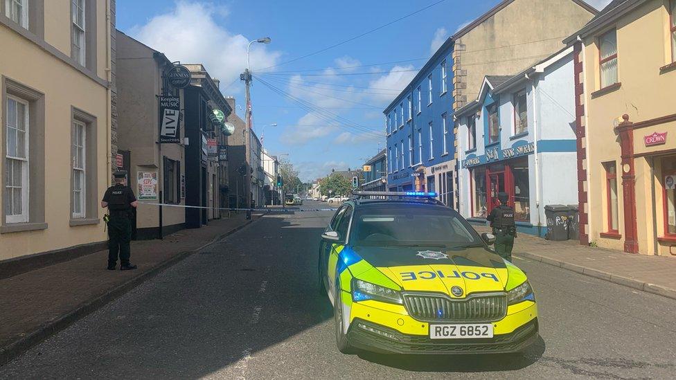 A police car and two police officers in Main Street in Castlederg, which is cordoned off