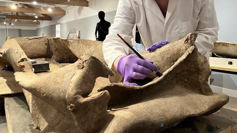 Conservator Emma Bowron working on the coffin at Leeds City Museum