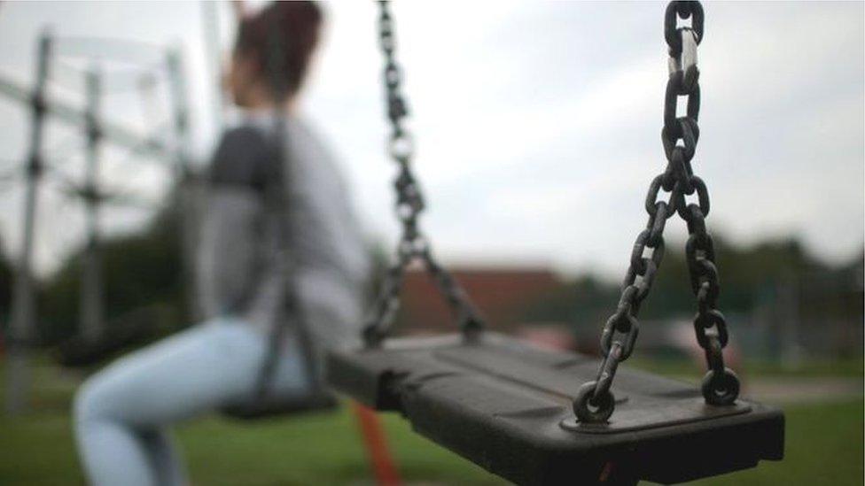 Child sitting alone on swing