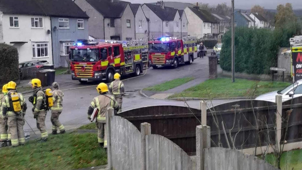 Scene of explosion with fire engines lined up on a road