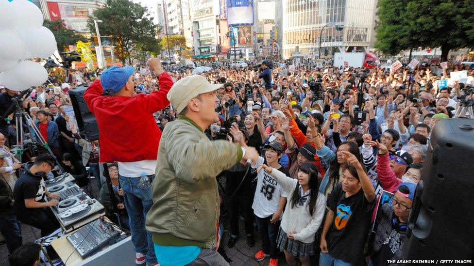 Performers in front of protest crowd, Tokyo