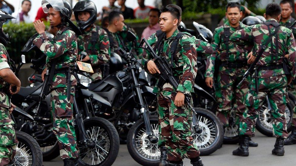 Armed Indonesian soldiers stand guard after gunfire and bomb blasts in front of a shopping mall in Jakarta, Indonesia, 14 January 2016