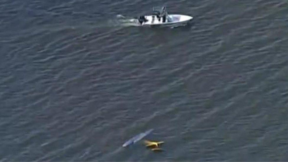 A rescue boat nears debris from a plane collision over a lake in Florida.