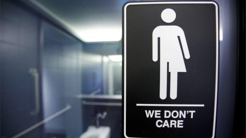 A sign protesting a recent North Carolina law restricting transgender bathroom access adorns the bathroom stalls at the 21C Museum Hotel in Durham, North Carolina, 3 May 2016