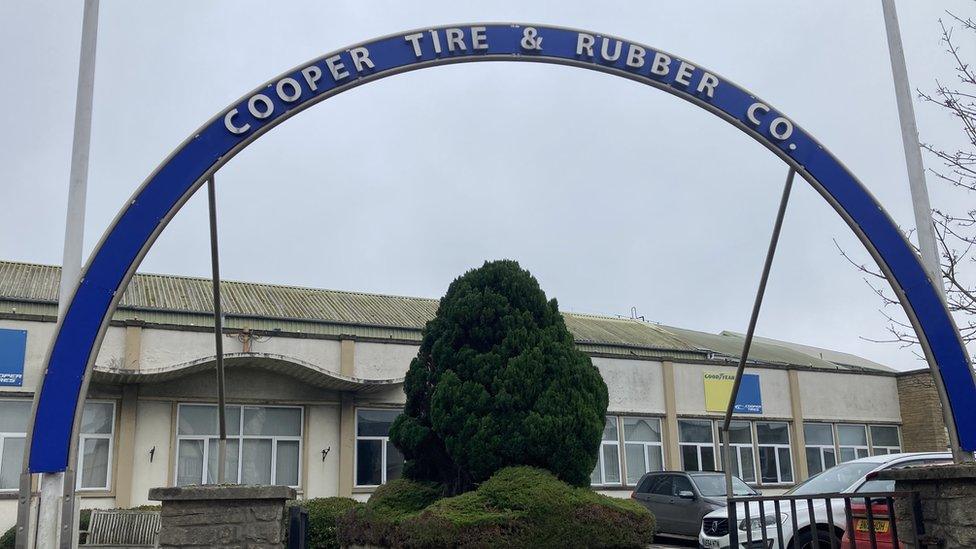 The entrance to Cooper Tires - an old factory building, with a curved sign over the entranceway