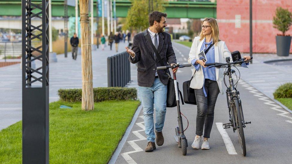 couple talking, on e-bike and e-scooter