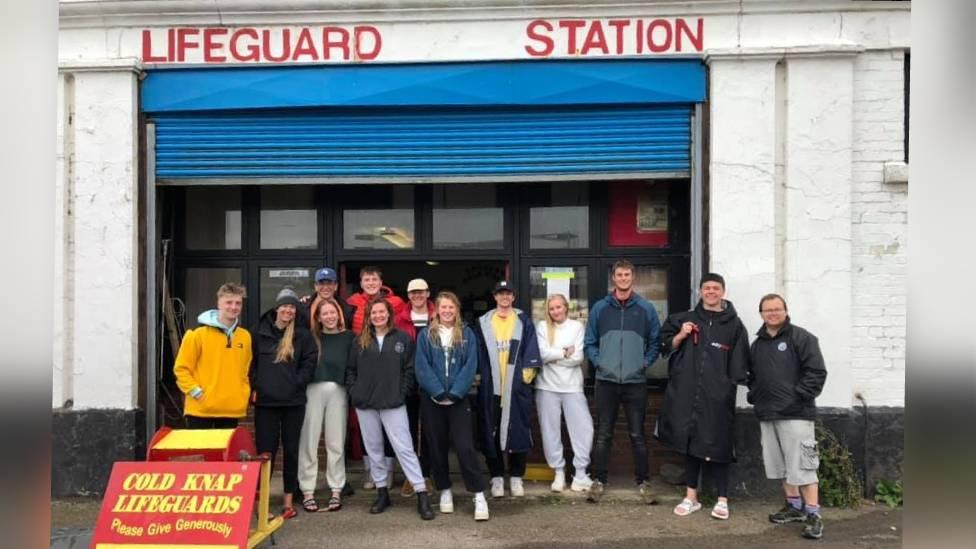 volunteers in front of a storage building