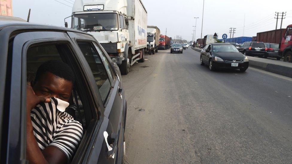 A man shields his nostrils in an attempt to avoid breathing the fumes