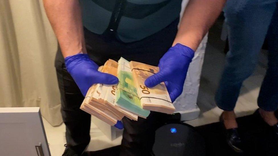 Police with wads of cash seized