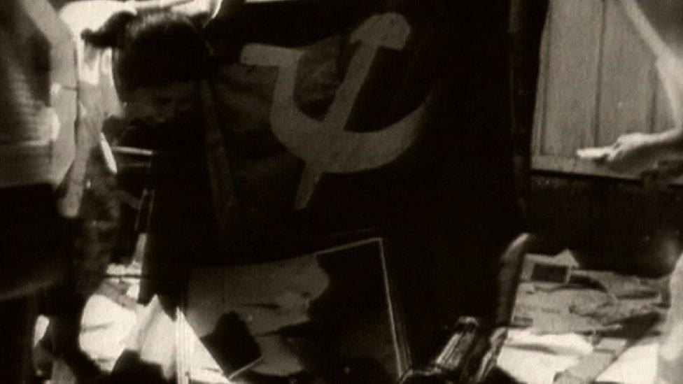 Black and white picture of a communist flag, taken from footage at the time.