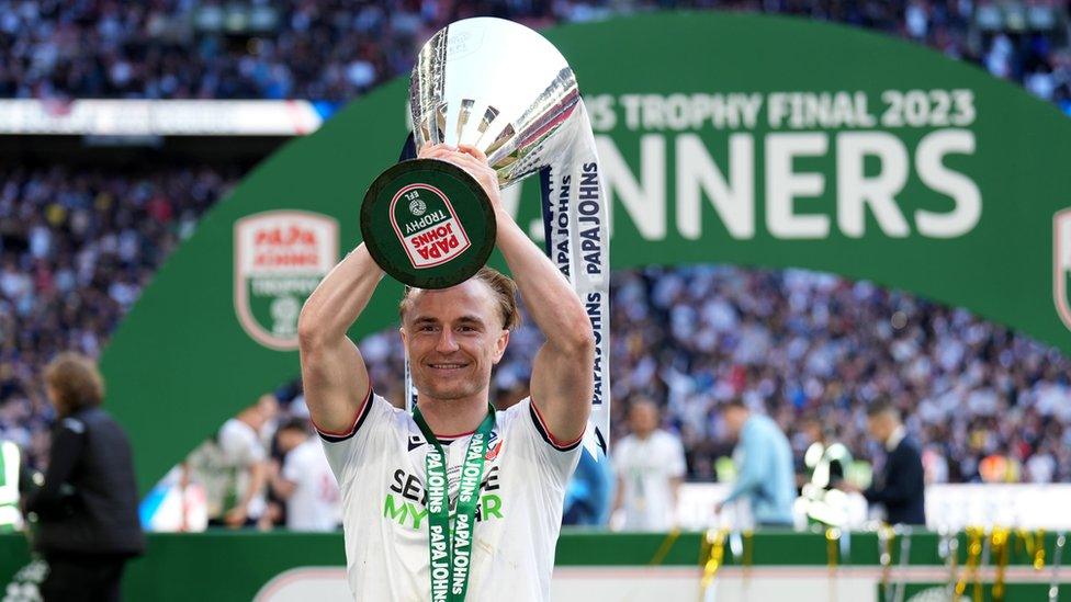 Kyle Dempsey holding up the Papa Johns Trophy at Wembley after this month after Bolton beat Plymouth Argyle