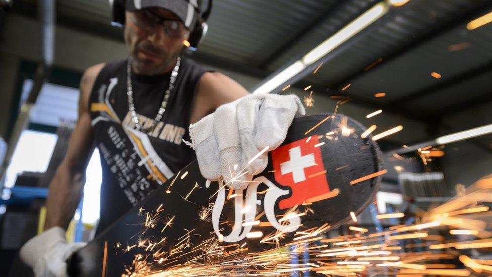 Man sharpens edges on skis at a Swiss factory