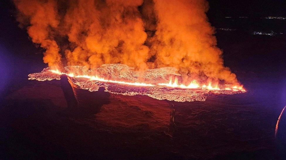 The volcano spews lava and smoke