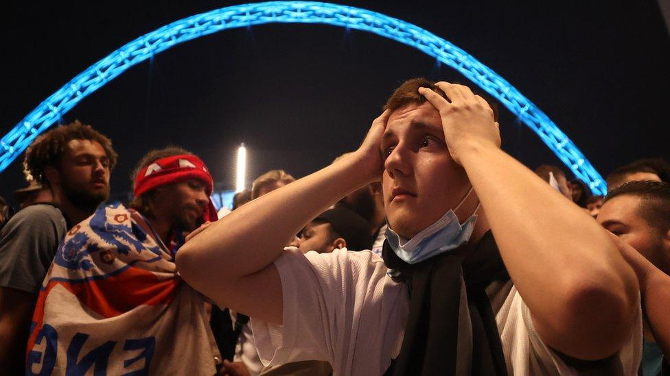 England fans react after Italy wins the Euro 2020 outside Wembley Stadium