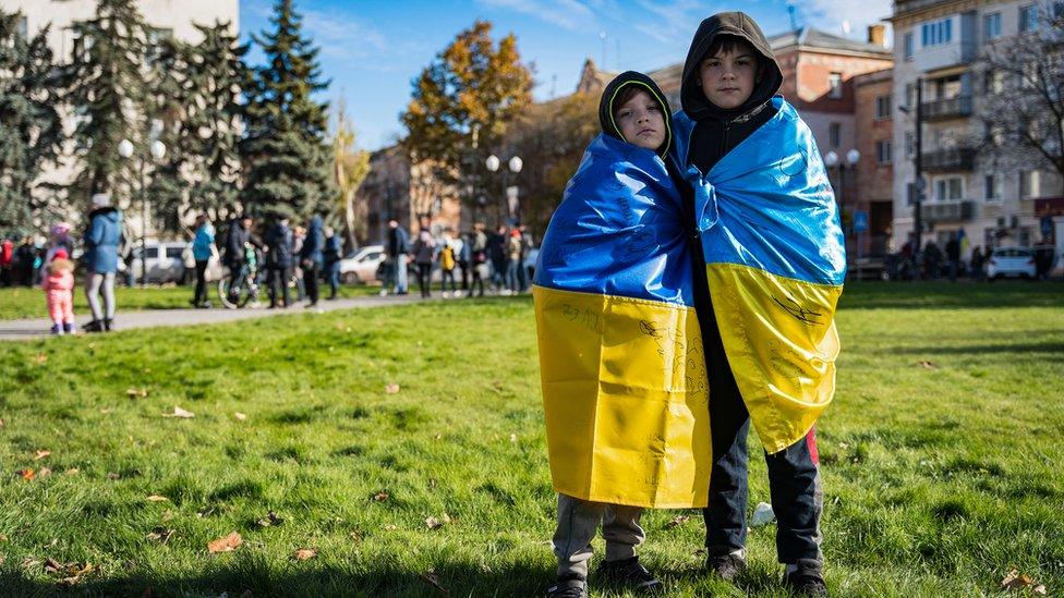 Two boys draped in the Ukrainian flags celebrated last November in Freedom Square following Russia's withdrawal from the city of Kherson.