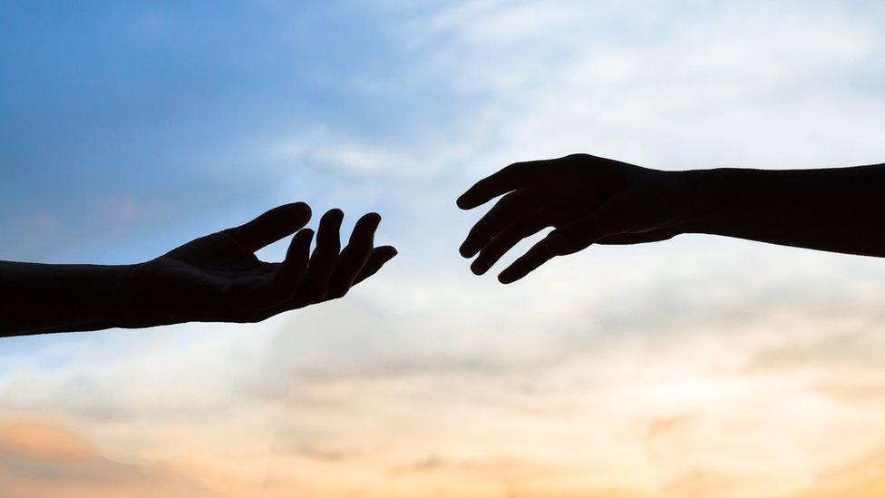 Silhouette of two hands meeting