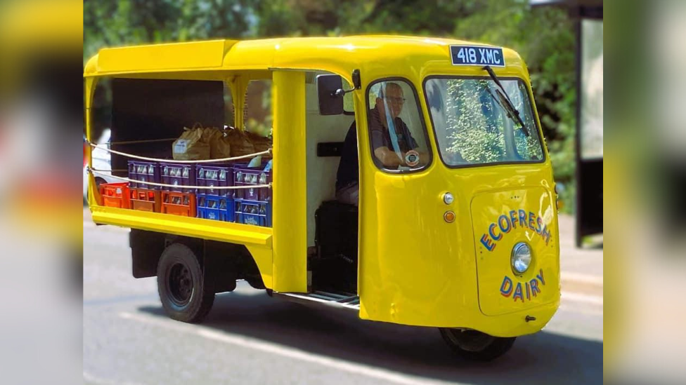 Paul Luke driving a yellow milk float