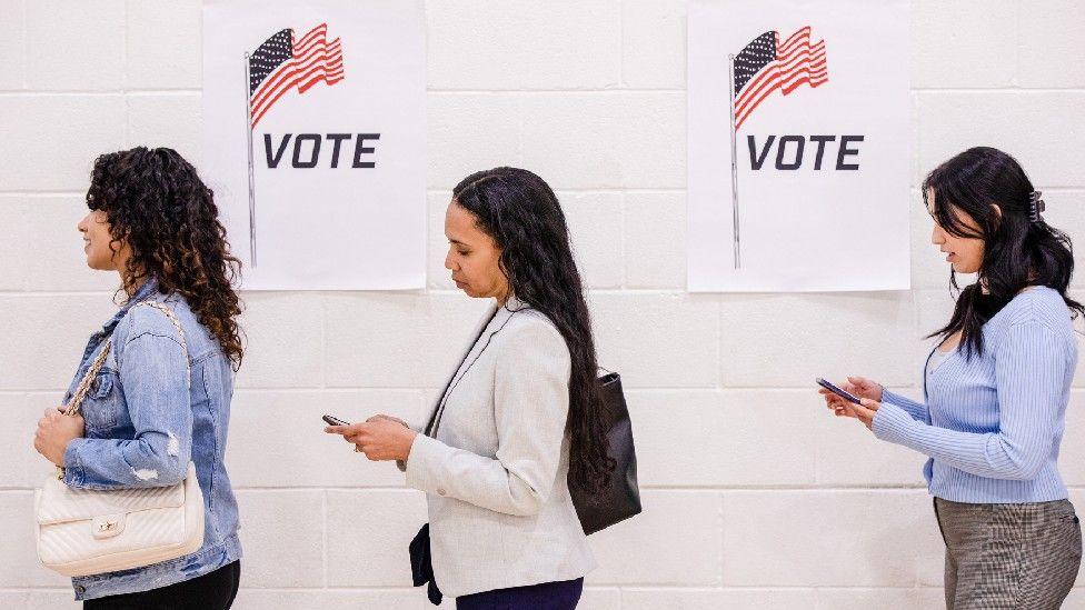 File image of three women standing in line to vote at a polling station