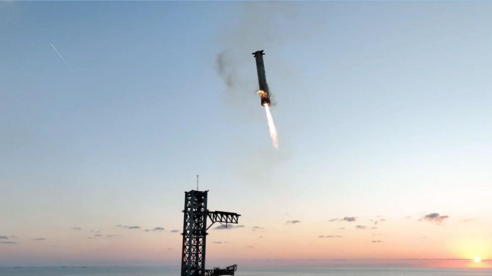 Booster being lowered back to the launchpad.