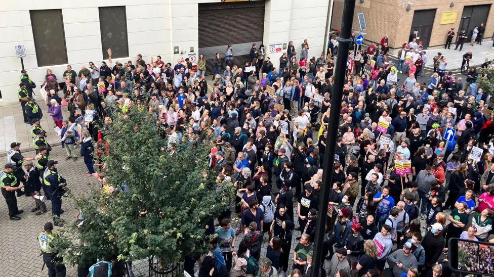 Crowd of counter-protestors behind a line of police