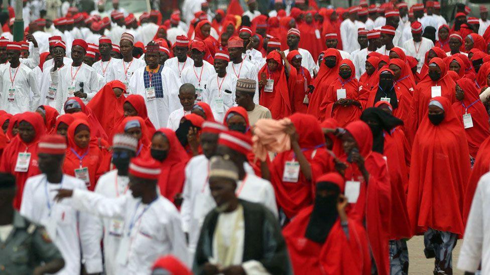 Brides in red and grooms in white arriving at the central mosque in Kano for a mass wedding - October 2023