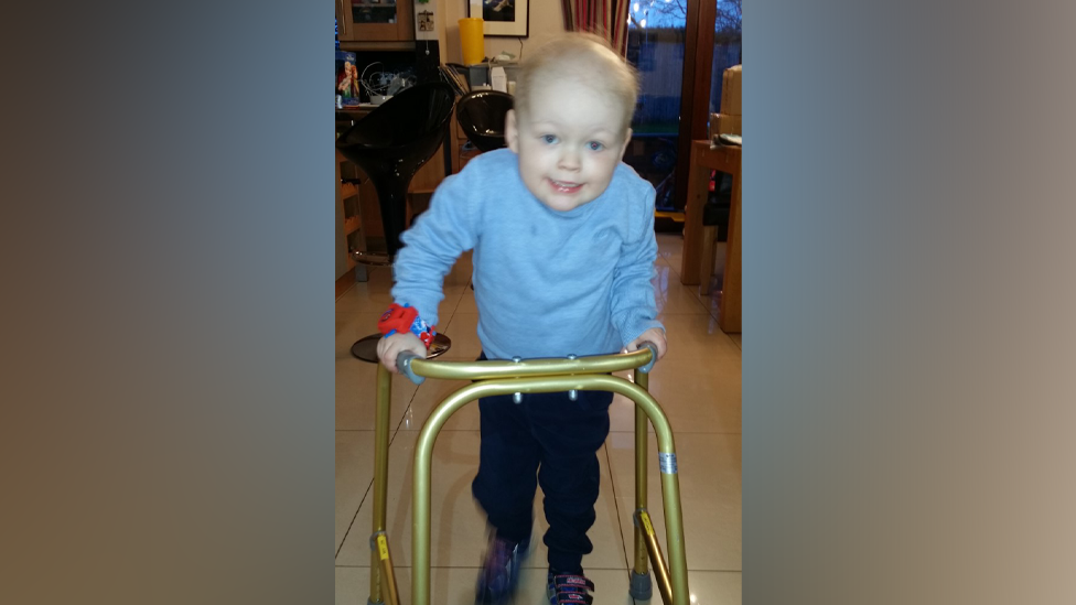 Carter as a young child, about five, using a frame to walk 