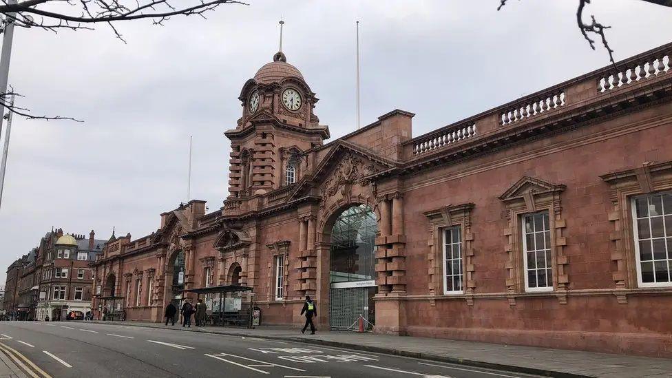 The ornate red bricked front of Nottingham Railway Station with its main entrances for passengers and a domed clock tower