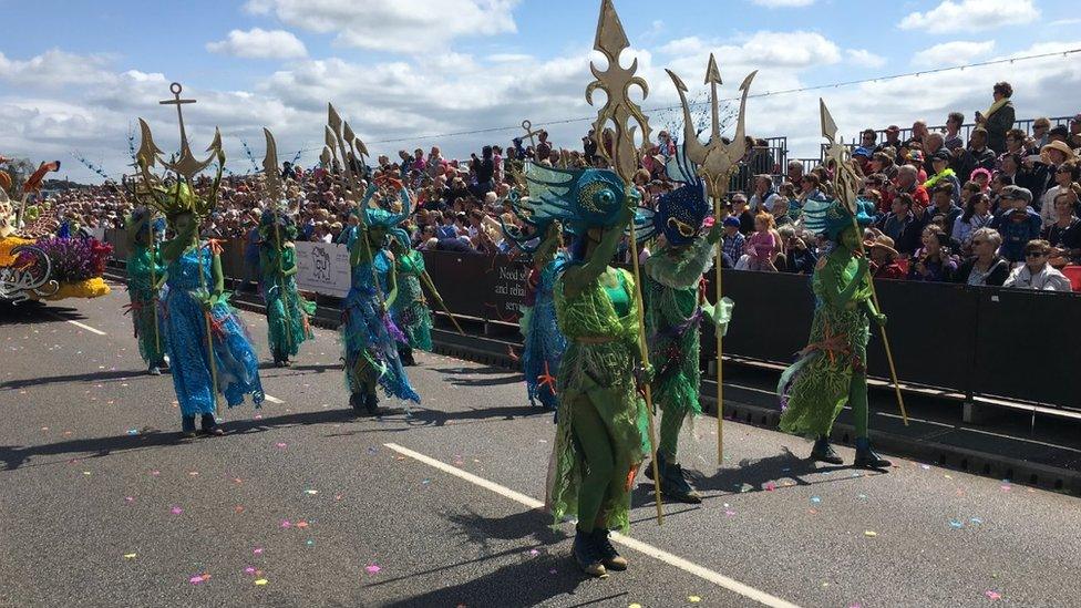 Dancers in front of float at battle of flowers in Jersey