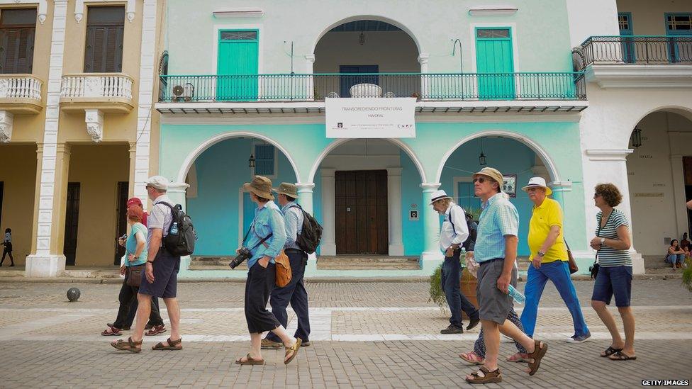 Tourists walking past a building in Old Havana