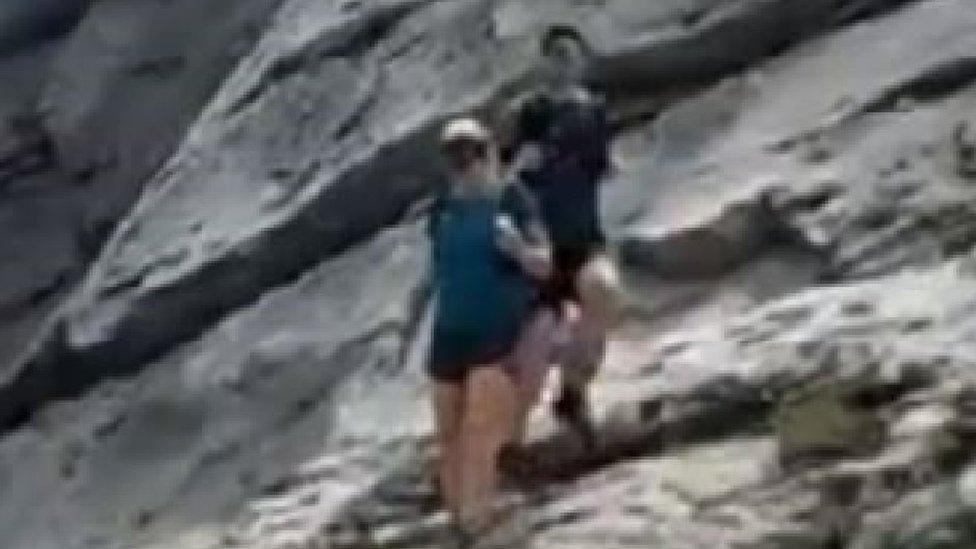 Grainy still of two people walking